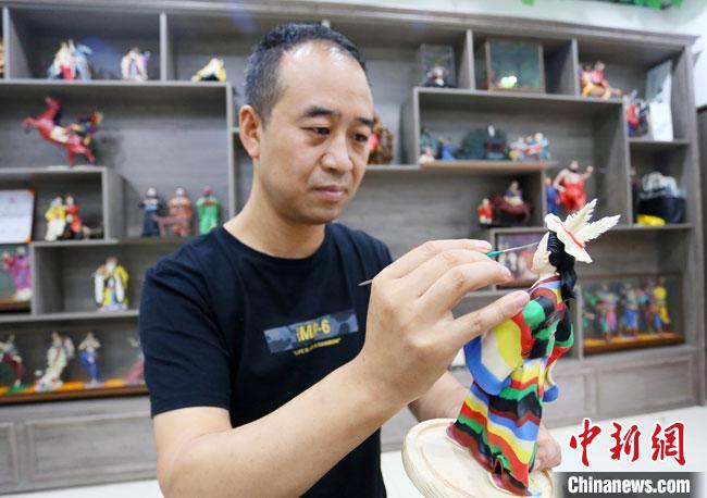 圖為安秋平正在創(chuàng)作代表隴南文縣民俗的《白馬人》作品?！「哒?攝