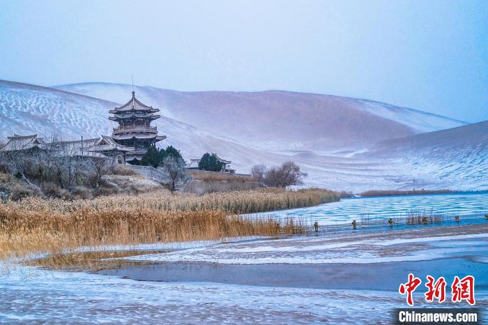2021年11月28日，雪落鳴沙山月牙泉景區(qū)。　王斌銀 攝