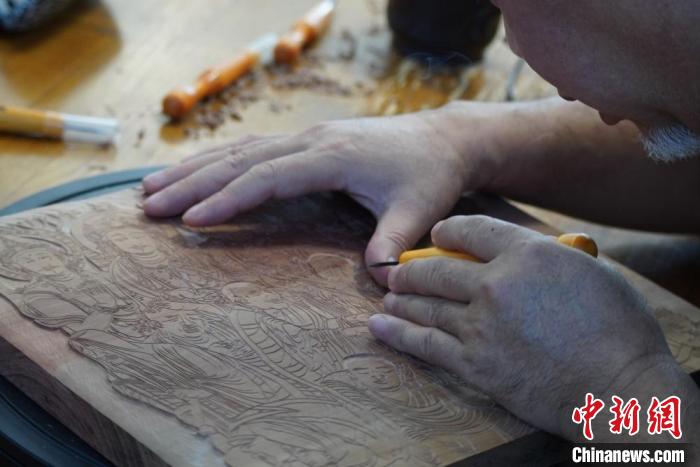 圖為徐晉林湊近木板，近距離制作雕版畫?！【琶赖┰?　攝