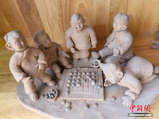 圖為泥塑作品展現(xiàn)下棋場景。 劉玉桃 攝