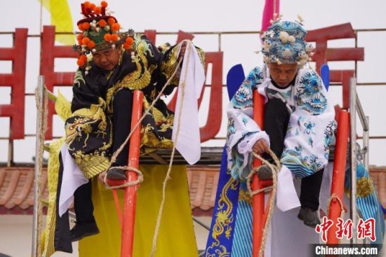 圖為“苦水高高蹺”表演者通過麻繩將腳固定在腳踏板，并在腿部纏繞六七圈?！【琶赖┰?攝