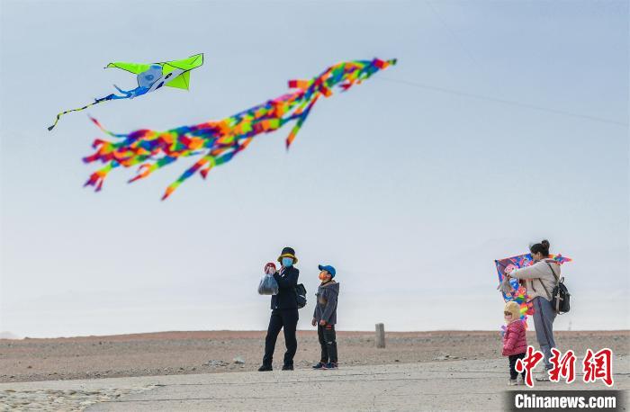 圖為孩童在父母的陪伴下放風(fēng)箏?！⊥醣筱y 攝