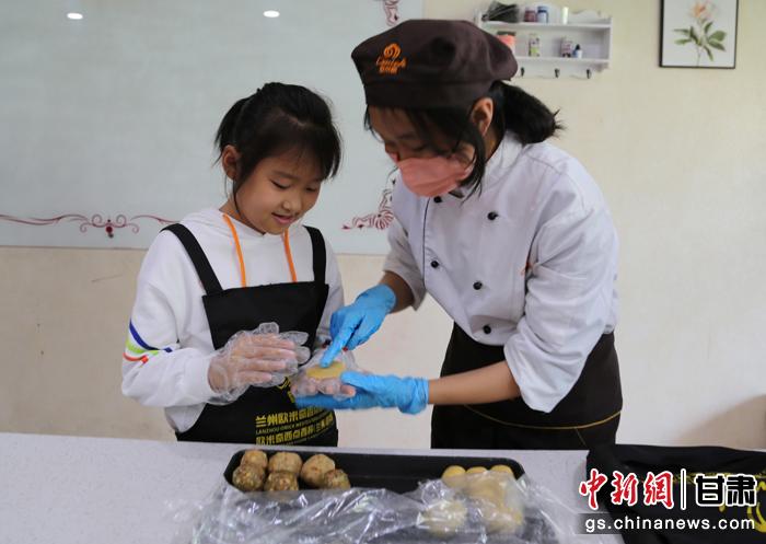 圖為在甘臺(tái)胞小朋友在工作人員指導(dǎo)下制作月餅。九美旦增 攝