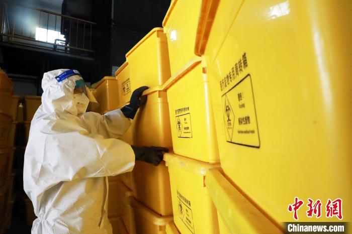 圖為工作人員搬運(yùn)醫(yī)療廢物專用周轉(zhuǎn)箱?！∥航ㄜ?攝