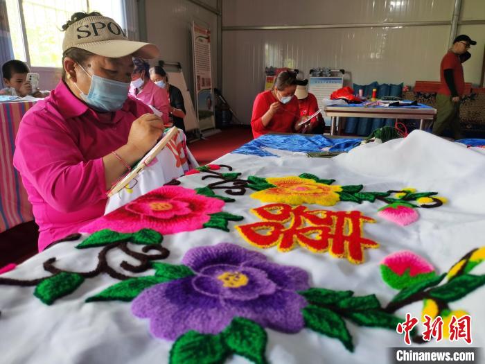 圖為婦女制作青繡?！?zhí)砀?攝