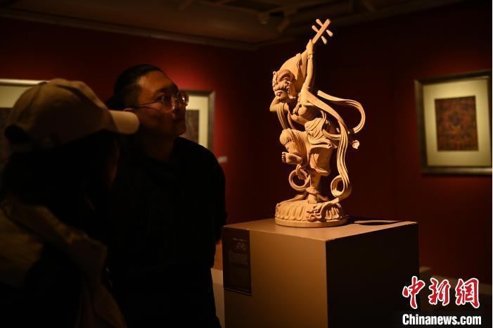 圖為季茂杰向參觀者介紹自己創(chuàng)作敦煌木雕的過程。李亞龍 攝</p>
<p>