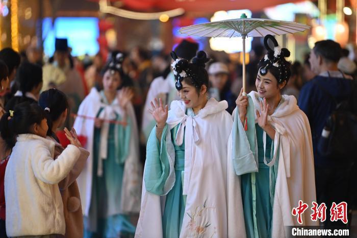 圖為街區(qū)人員著傳統(tǒng)服飾與游人互動(dòng)。李亞龍 攝</p><p>