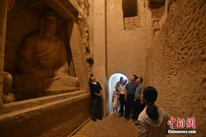 7月15日，游人參觀甘肅省平?jīng)鍪袥艽h百里石窟長(zhǎng)廊中的王母宮石窟。百里石窟長(zhǎng)廊位于涇川縣境內(nèi)，由512個(gè)石窟、5眼窟中石井組成，現(xiàn)存王母宮石窟、鳳凰山石窟、南石窟寺、丈八寺石窟、羅漢洞石窟、太山寺石窟等規(guī)模較大的石窟群，還有數(shù)量眾多的小石窟群。王母宮石窟又名千佛洞，該窟設(shè)計(jì)宏大，造像生動(dòng)，窟內(nèi)擁有造像數(shù)百尊，是較為珍貴的佛教文化歷史遺存。中新社記者 李亞龍 攝</p>
<p>